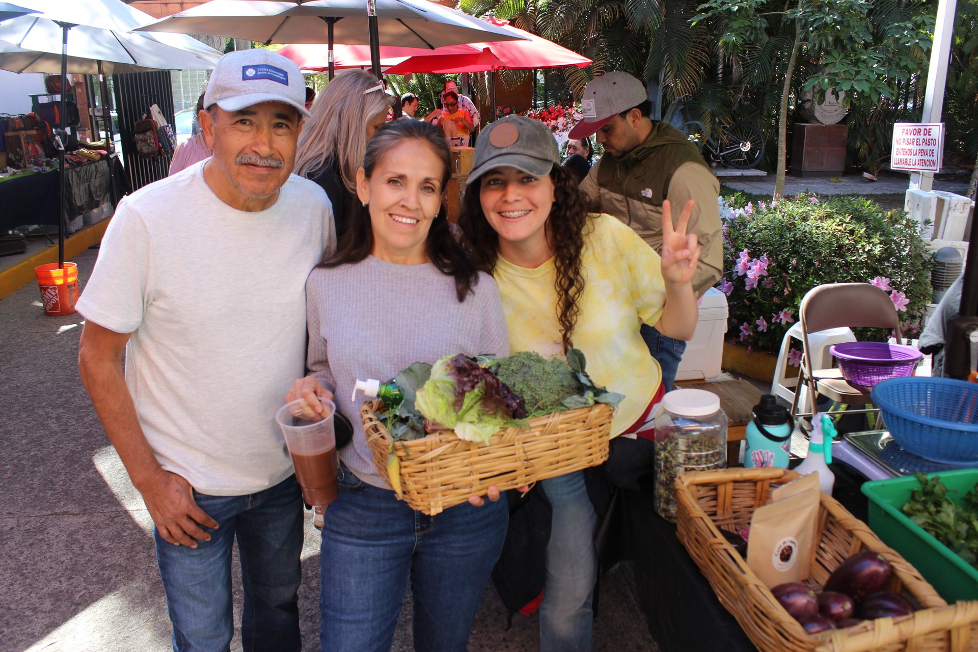 Una familia con una canasta de verduras recién compradas en la Feria de Productores