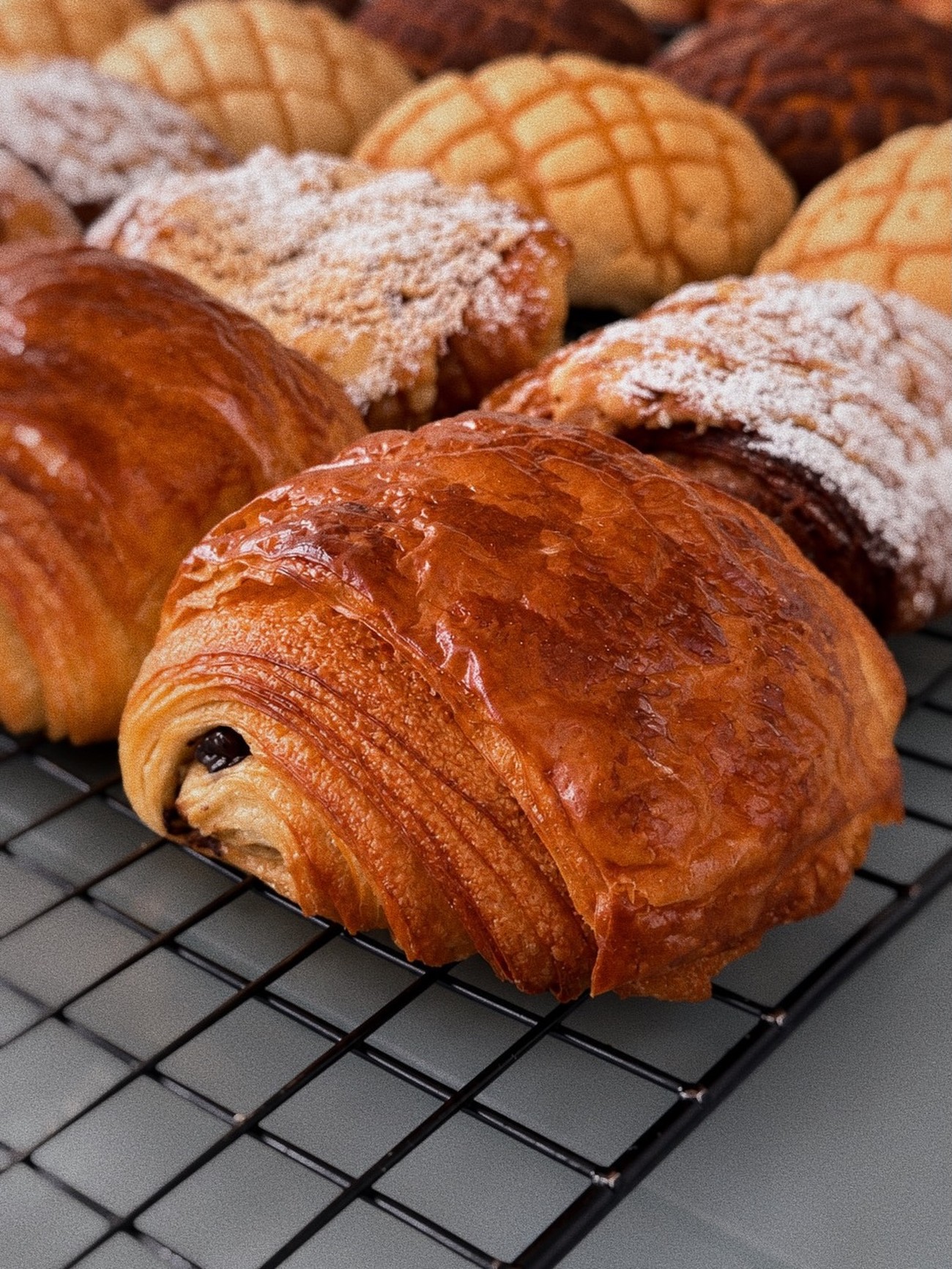 Pan dulce y pain au chocolat recién horneados de Gran Pan, sobre una rejilla de enfriamiento