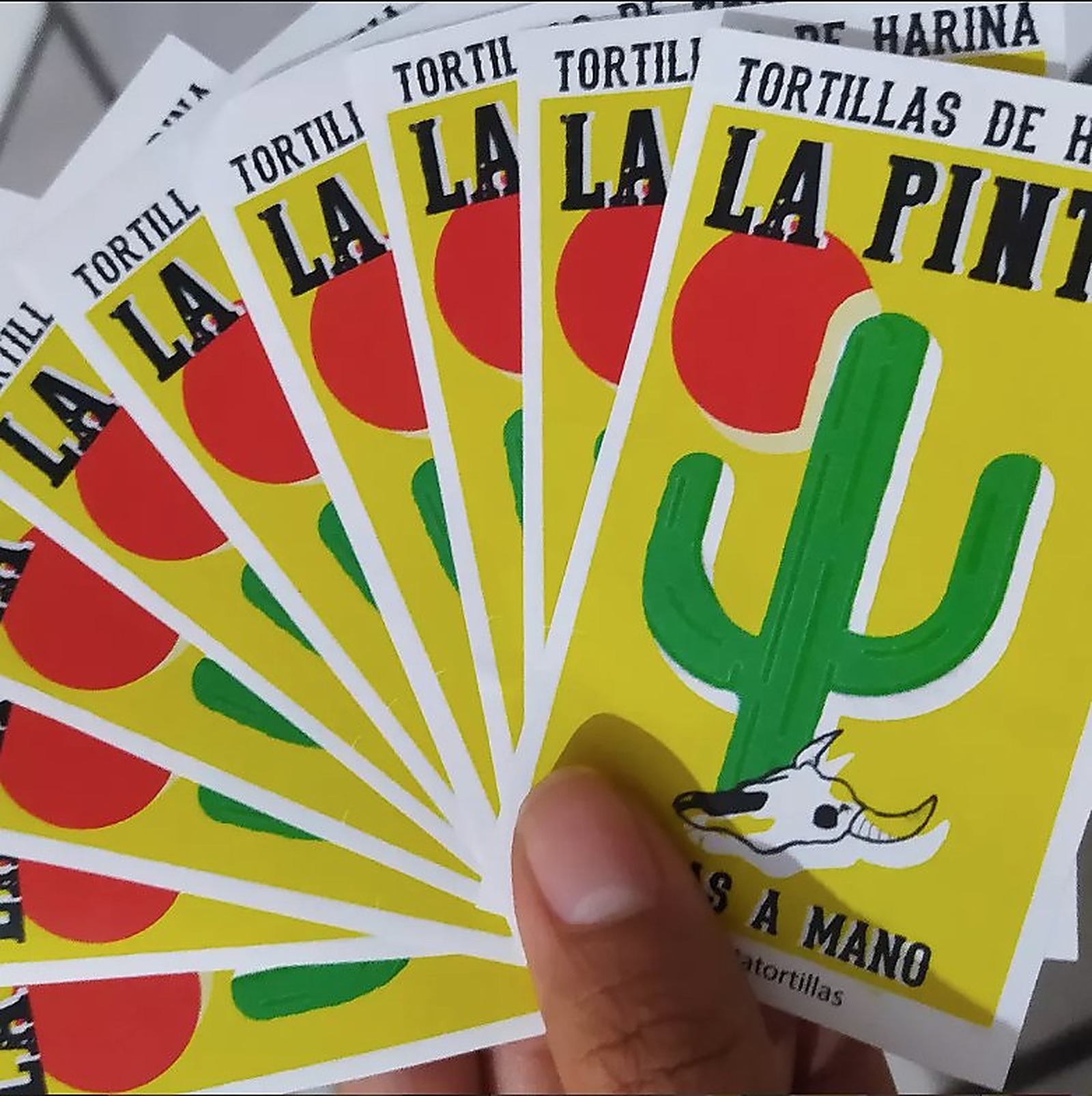 Paquetes de Tortillas de Harina La Pinta en abanico, con logo de cactus y calavera de vaca