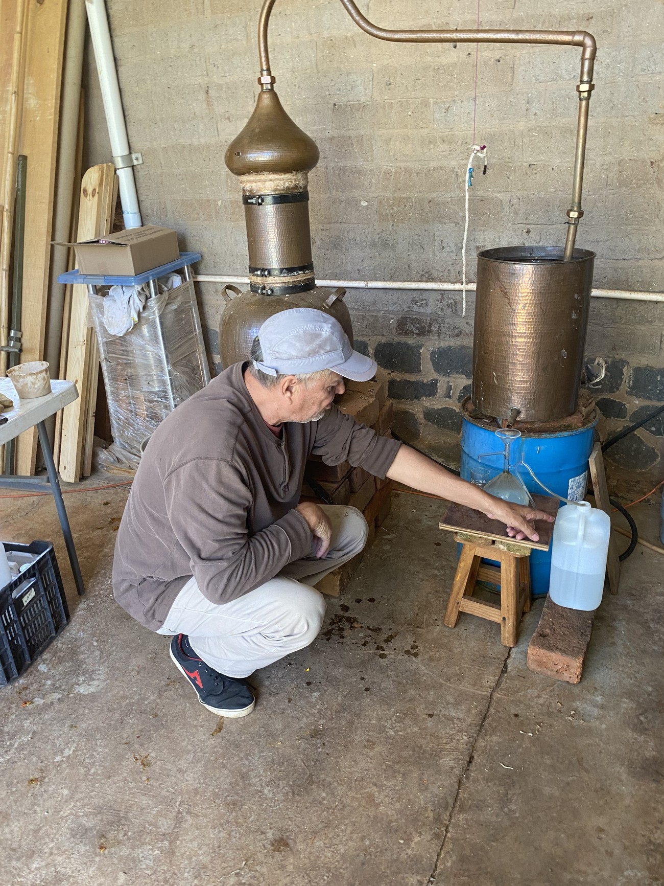 Productor de Suelo Feliz operando un alambique de cobre tradicional para destilar hidrosol