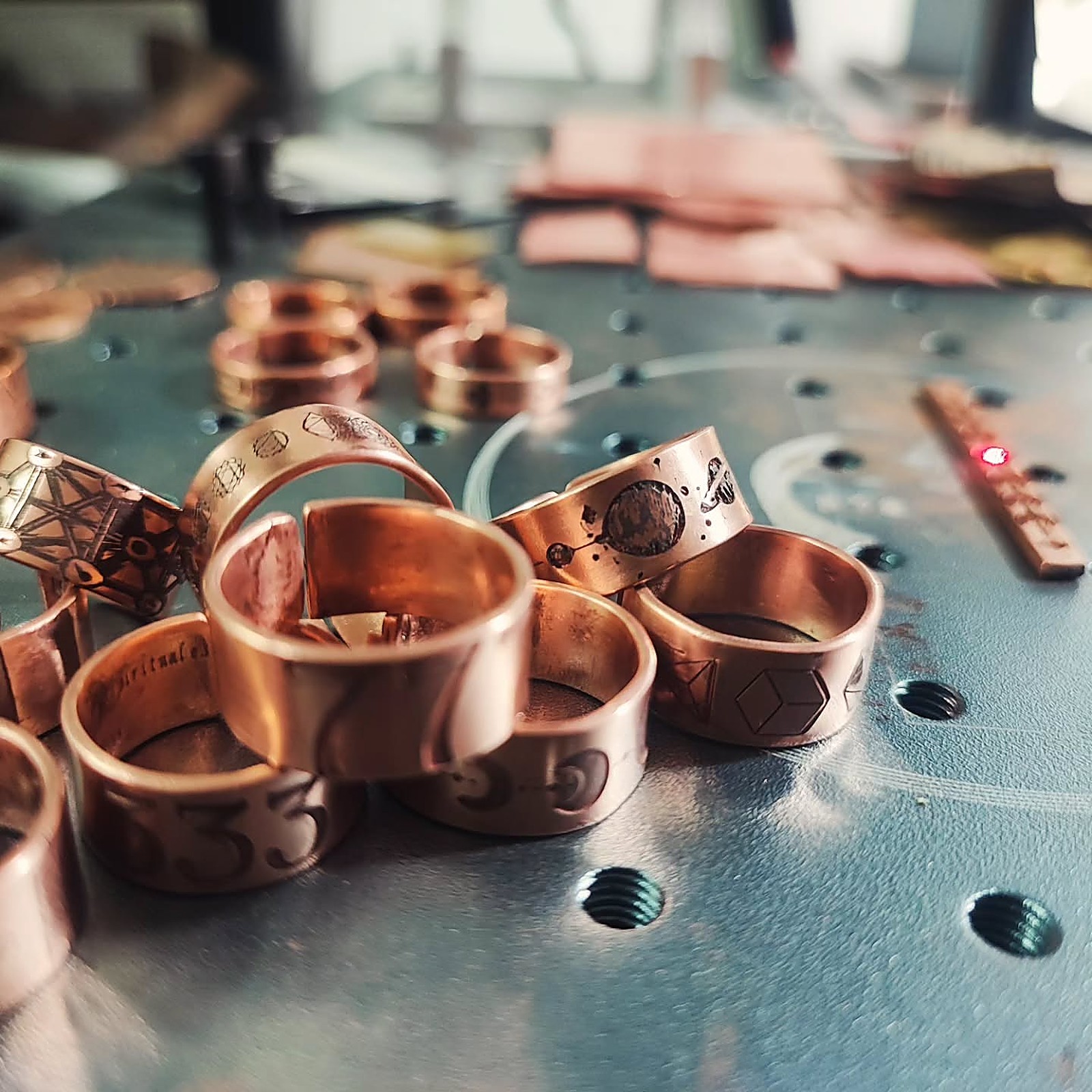 Anillos de cobre martillado y grabado de Yolteótl Joyería, recién salidos del taller, sobre una mesa de trabajo